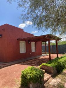 ein rotes Haus mit einem Pavillon davor in der Unterkunft Cabaña Chañares de Banda Florida - Sveña in Villa Unión