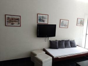Habitación con cama y TV de pantalla plana en la pared. en Edificio VALLE & VALLE en Mar del Plata