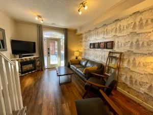 a living room with a couch and a tv at Mountain Chalet at Mystic Springs, 2BR, 2BA, Heated Pool, Hot Tub! in Canmore