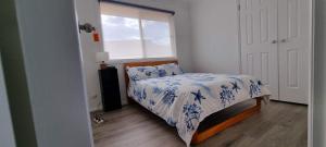 ein kleines Schlafzimmer mit einem Bett und einem Fenster in der Unterkunft Shellharbour. Ocean, lake and mountain view in Shellharbour