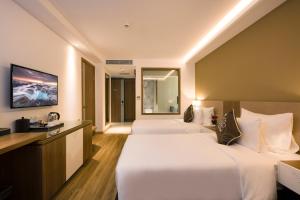 Postel nebo postele na pokoji v ubytování Comodo Nha Trang Hotel