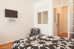 1 dormitorio con 1 cama y TV de pantalla plana en IPANEMA - EXCELENTE APARTAMENTO NA MELHOR LOCALIZAÇÂO, 2 quadras da praia!!!, en Río de Janeiro