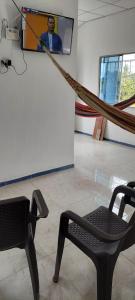 Cette chambre comprend un hamac et une chaise. dans l'établissement HOSTAL ZAS, à Mompos