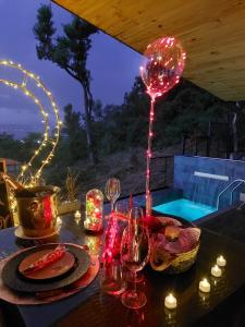 una mesa con velas, copas de vino y luces en Vista Lago Suites PY en Itauguá