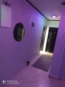 een paarse kamer met een deur en een spiegel bij Hotel La coline in Beni Mellal