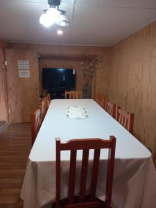 a dining room with a white table and chairs at Umantü Hostel in Panguipulli