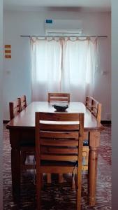 een eettafel met stoelen en een wit gordijn bij Diaz Deptos in La Rioja
