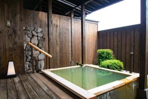 a bath tub sitting on a wooden deck at Senomoto Kogen Hotel in Minamioguni