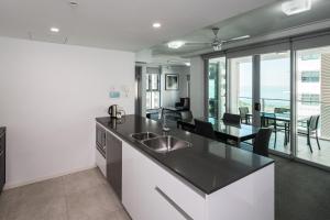 a kitchen and dining room with a view of the ocean at H on Mitchell Apartment Hotel in Darwin