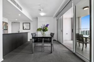 a dining room with a table and chairs at H on Mitchell Apartment Hotel in Darwin
