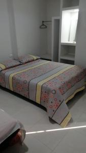 a bed sitting in a room with a bedspread on it at Villa Myrian in Villanueva