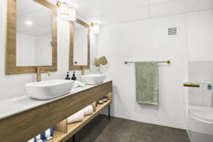 a bathroom with two sinks and a mirror at Kiama Shores in Kiama