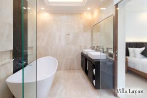 a bathroom with a tub and two sinks and a bed at Villa Mia Seminyak - Boutique Villas in Seminyak