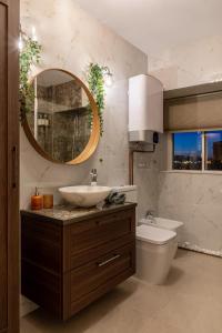 een badkamer met een wastafel, een toilet en een spiegel bij HOLT - Bagheera's Den in Boekarest
