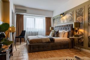 een slaapkamer met een bed en een bank bij HOLT - Bagheera's Den in Boekarest