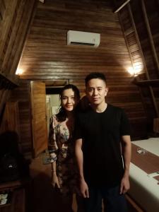 un hombre y una mujer de pie en una habitación en Kubu Penida Villa en Nusa Penida