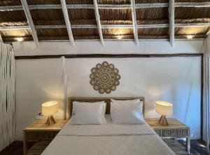 ein Schlafzimmer mit einem Bett und zwei Lampen an Tischen in der Unterkunft NENA BEACH CLUB & HOTEL in Barú