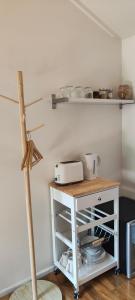 uma cozinha com uma mesa branca e uma prateleira em Zen Abode with Garden in Eltham em Eltham