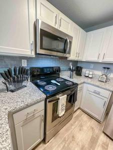 a kitchen with a stove and a microwave at WOO LOFT- King Bed- Downtown BHM in Birmingham