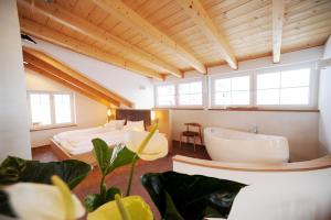 a bathroom with two beds and a tub and a sink at dolomit24 | design apARTments in Sillian