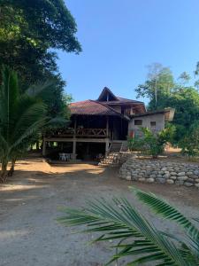 a house with a stone wall in front of it at Playa Tortuga in Puerto Misahuallí