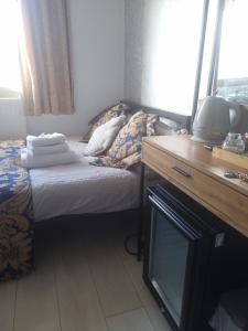 a small bedroom with a bed and a tv at LONDON ROOM 1 in London