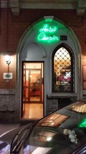 una señal de neón en la parte delantera de una tienda en Hotel Chopin, en Milán