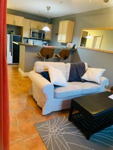 a living room with a couch and a kitchen at Condo entier, fully equiped pool and Spa only in summer in Mont-Tremblant