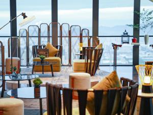 une chambre avec des chaises, des tables et une grande fenêtre dans l'établissement Hotel Indigo Suzhou Grand Canal, an IHG Hotel, à Suzhou
