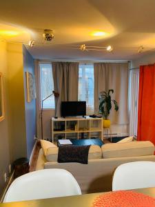uma sala de estar com dois sofás e uma televisão em Condo entier, fully equiped pool and Spa only in summer em Mont-Tremblant