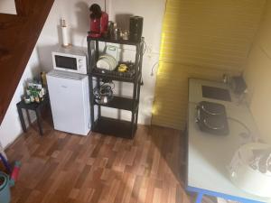 a small kitchen with a refrigerator and a microwave at Citron vert in Port-Louis
