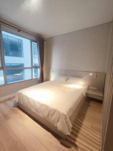 une chambre avec un lit avec une grande fenêtre dans l'établissement The Rixx Business Apartment @D1/Netflix/sauna/gym, à Hô-Chi-Minh-Ville