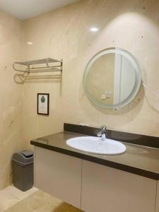 une salle de bain avec un lavabo et un miroir dans l'établissement The Rixx Business Apartment @D1/Netflix/sauna/gym, à Hô-Chi-Minh-Ville