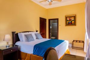 a bedroom with a large bed and a bathroom at Art Hotel Boutique in San Pedro Sula