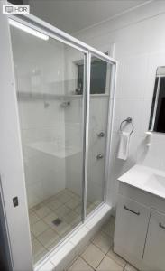 a white bathroom with a shower and a sink at Lithgow Motor Inn in Lithgow
