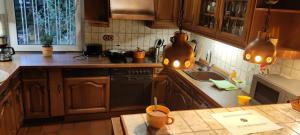 uma cozinha com armários de madeira e um balcão com luzes em Uni-nähes Apartmenthaus mit Garten em Bochum