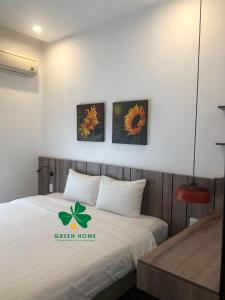 ein Schlafzimmer mit einem Bett mit einem grünen Schild darauf in der Unterkunft PARKVIEW Apartments in Haiphong