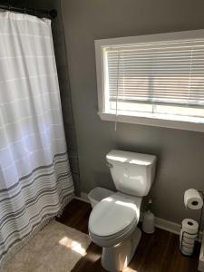 uma casa de banho com um WC branco e uma janela em Clark Creek Ranch Cabin em Medina