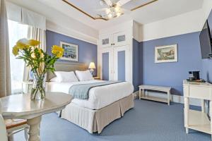 um quarto com uma cama e um vaso de flores sobre uma mesa em Cornell Hotel de France em São Francisco