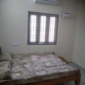 a bed in a room with a window at ARS furnished house in Chrompet
