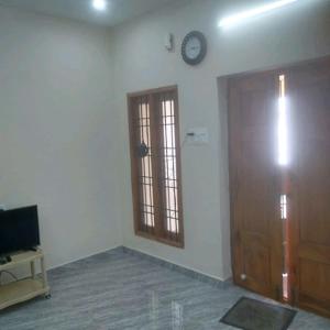 a room with a clock on the wall and a door at ARS furnished house in Chromepet