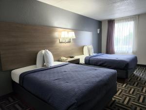 a hotel room with two beds and a window at Relax Inn in Hendersonville