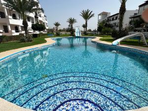 - une piscine d'eau bleue dans un complexe dans l'établissement Entire apartement in Cabo Negro Family only, à Tetouan