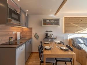 a kitchen and dining room with a table and chairs at Appartement rénové proche des pistes avec WiFi et linge inclus - FR-1-640-10 in Val Thorens