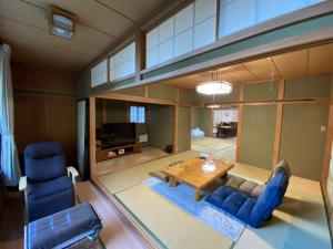 sala de estar con mesa y sillas azules en 富士山を望むプレミアムヴィラ Borealis BBQ設備有, en Oishi