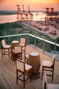 een terras met tafels en stoelen en uitzicht op de oceaan bij The Rangoon Hotel in Yangon