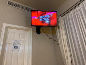 une télévision à écran plat suspendue sur un mur à côté d'une porte. dans l'établissement HOTEL COLONIAL MATAMOROS, à Matamoros