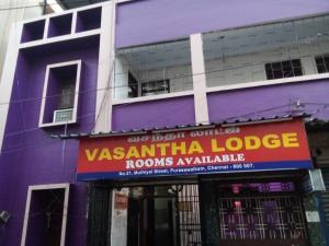 Un bâtiment violet avec un panneau indiquant le lodge vashantilla dans l'établissement Vasantha Lodge Purasawalkam chennai, à Chennai