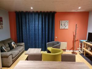 ein Wohnzimmer mit einem Sofa, Stühlen und einem Tisch in der Unterkunft Le Rouge Gorge Curieux in Vresse-sur-Semois