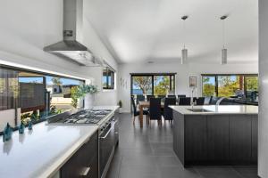 a kitchen with a stove and a dining room at NEW - Sunrise Waters Holiday House in Mulwala